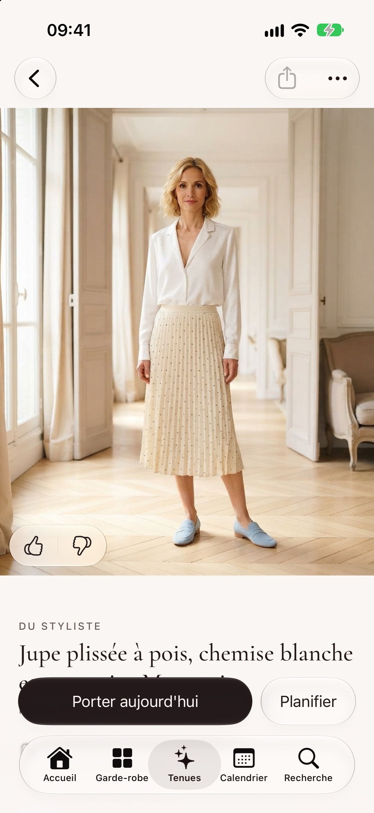 Une tenue du styliste en photo : jupe plissée à pois, chemise blanche et mocassins bleu ciel.